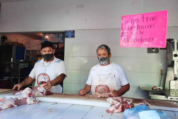 Por obligación y protección usan cubre bocas en negocios del puerto