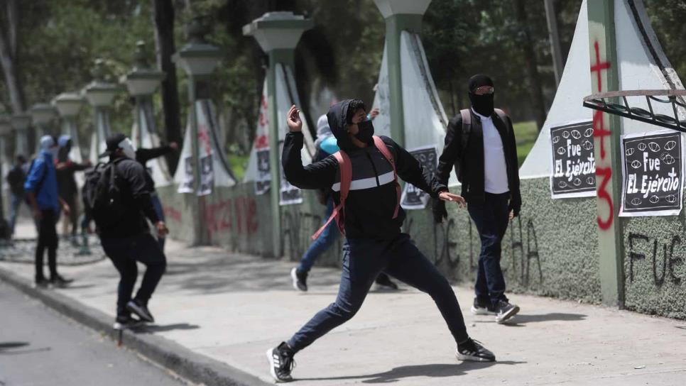 Familiares y amigos de normalistas de Ayotzinapa se enfrentan a policías en manifestación